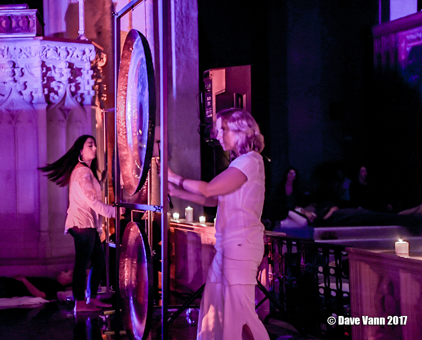 Two women playing gongs during a sound healing symphony event